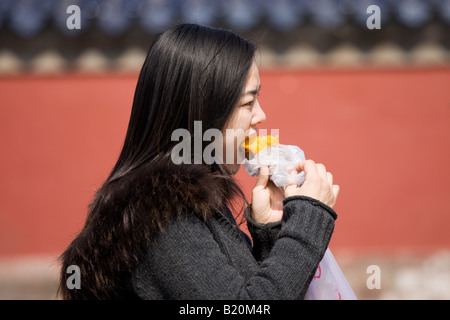 Girl eating yam patate douce à la dynastie des Ming, le Temple du Ciel Pékin Chine Banque D'Images