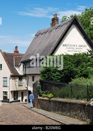 Homme qui marche dans la dernière rue pavée d'ARMES BRITANNIQUES DE ELM HILL NORWICH Banque D'Images