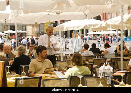 Espagne Madrid waiter taking order sur le pad au parapluie en plein air sur la Plaza Mayor table commande de menu alimentaire couple Banque D'Images