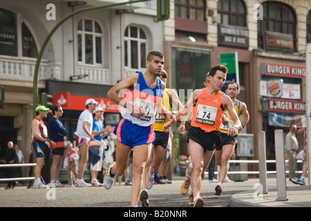 Espagne Madrid coureurs homme vérifier watch en course de marathon sur la rue Gran Via avec les spectateurs Banque D'Images