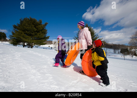 Une femme et son jeune fils l'ascension d'une colline de la luge à Quechee, Vermont. Banque D'Images