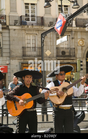 Espagne Madrid Membres de mariachis chanter et jouer de la guitare sur la Plaza del Sol signe métro musique et costumes traditionnels mexicains Banque D'Images