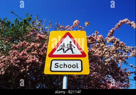 Panneau d'avertissement de passage à niveau scolaire dans la voie de l'avenir par des arbres fleuris au printemps près de Leeds Yorkshire UK Banque D'Images