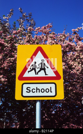 Panneau d'avertissement de passage à niveau scolaire dans la voie de l'avenir par des arbres fleuris au printemps près de Leeds Yorkshire UK Banque D'Images