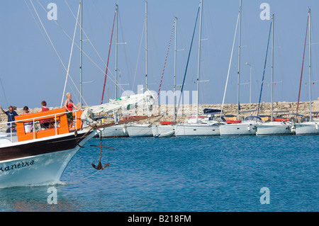 Le port de Mandraki sur l'île de Rhodes avec certaines des yachts amarrés et une journée touristique voile mis en avant. Banque D'Images