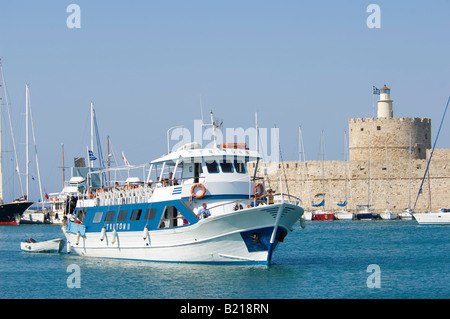 Le port de Mandraki sur l'île de Rhodes avec une île à l'entrée en bateau port à la fin de la journée. Banque D'Images