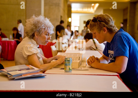 La recherche de conseils sur le collège qui d'assister à un élève du secondaire en chèques avec une réceptionniste dans un collège juste à Los Angeles Banque D'Images