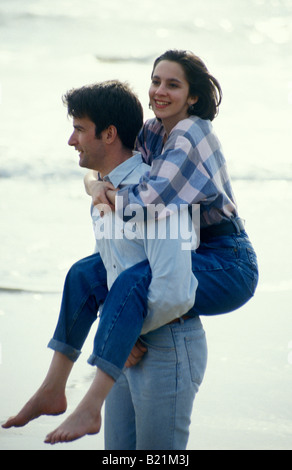 Jeune couple sur la plage petite amie ayant piggyback Banque D'Images