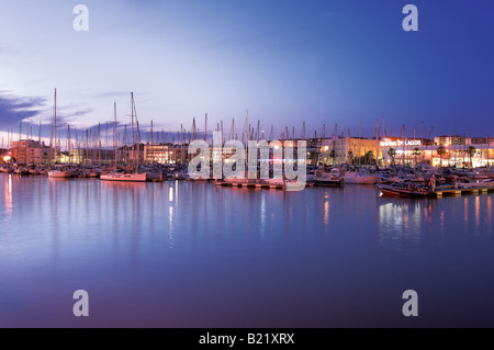 Port de plaisance de Lagos au coucher du soleil en Algarve au sud du Portugal. Les voiliers et les navires reposent dans des quais sûrs berth dans le calme paisible nuit réflexions de la mer Banque D'Images