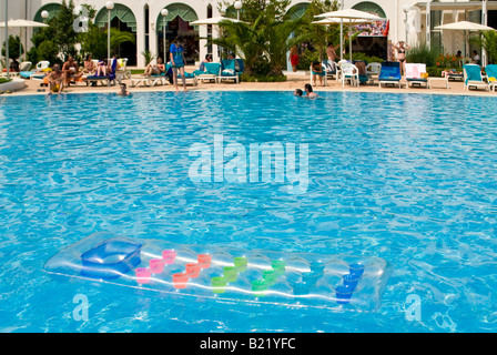 Grand angle de visualisation horizontal d'un lilo gonflable vide flottant dans une piscine à un grand hôtel moderne Banque D'Images