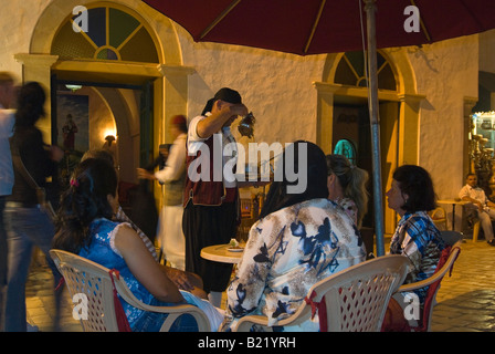 Close up of a horizontal waiter pouring out plateau traditionnel tunisien à l'Arabe chers à une table de nuit. Banque D'Images