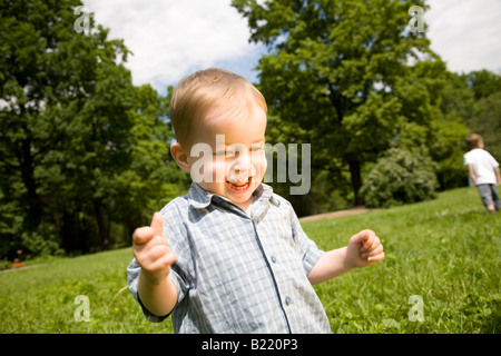 Heureux souriant petit garçon dans le parc Banque D'Images