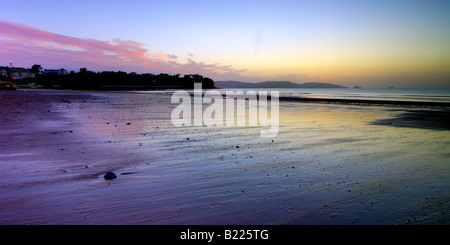 Juste avant l'aube sur l'estran au musée dans le sud du Devon avec la première lueur de la lumière du soleil reflétant sur le sable humide Banque D'Images