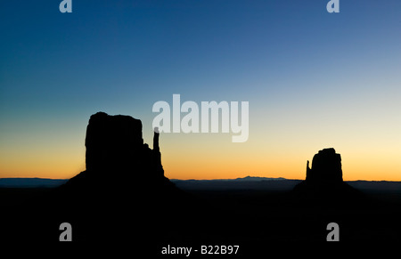 Monument Valley coucher du soleil sur les terres des Amérindiens dans le sud-ouest américain avec des silhouettes de la célèbre mitten butte formations Banque D'Images