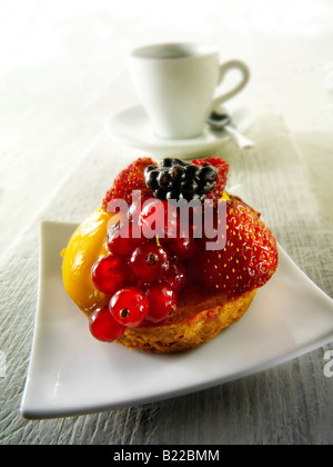 Un fruit d'été frais gâteau individuel avec mousse aux framboises dans un café avec café Banque D'Images