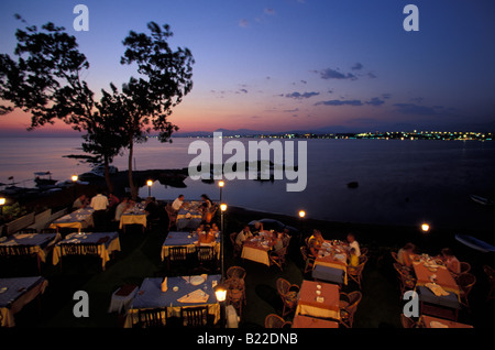 Les gens assis dans un restaurant de plage en fin de soirée Side Antalya Turquie Riviera turque Banque D'Images