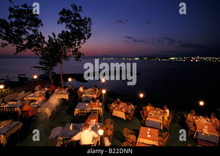 Les gens assis dans un restaurant de plage en fin de soirée Side Antalya Turquie Riviera turque Banque D'Images