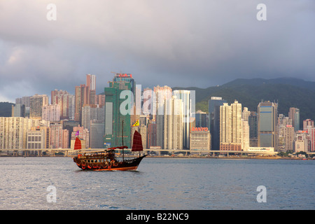 Junk ship avec l'île de Hong Kong skyline en arrière-plan vue du continent de Kowloon Banque D'Images