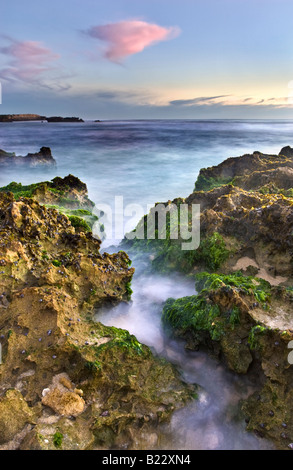 L'eau qui coule à travers un trou dans la roche calcaire à Perth's Trigg Beach. L'ouest de l'Australie Banque D'Images