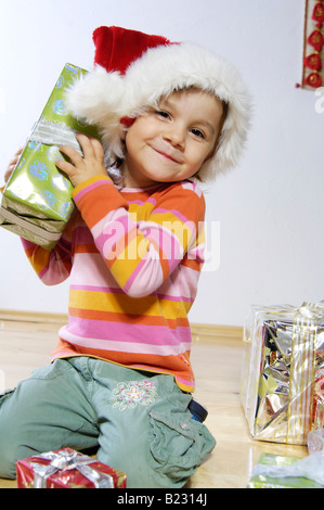 Portrait of Girl holding Christmas Gift and smiling Banque D'Images