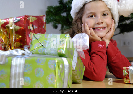 Portrait of Girl lying on floor with christmas gifts Banque D'Images