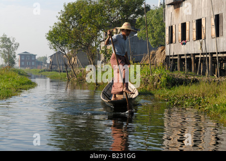 L'homme sur le bateau en rivière, lac Inle, Myanmar Banque D'Images