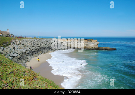 Les jeunes garçons le surf et jouer dans l'océan pacifique sur une section isolée de la plage le long de West Cliff drive santa cruz en Californie Banque D'Images