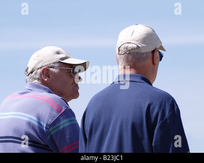 Deux vieux hommes portant des casquettes de baseball, pris par derrière. Banque D'Images