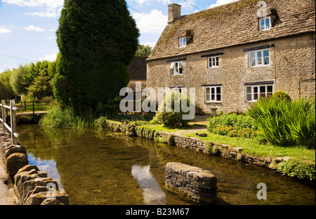 La Tamise s'écoulant en un pays typique en pierre de Cotswold House dans le village de Ashton Keynes, Wiltshire, England, UK Banque D'Images