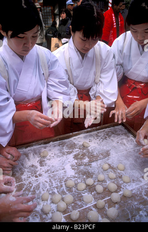 Lieu de culte appelé assistants miko font des boules de mochi à partir de pâte de riz battu lors de festivités de la nouvelle année Banque D'Images