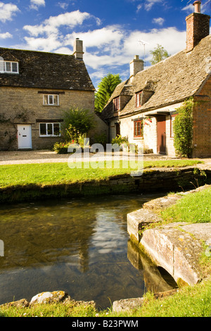Maisons de village en pierre de Cotswold country à l'église à pied par millstream, Ashton Keynes, Wiltshire, England, UK Banque D'Images