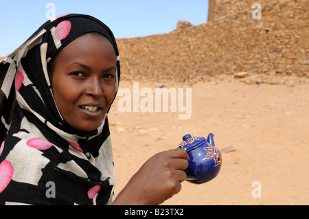 Fille avec un pot de thé dans ses mains Ouadane l'Afrique de l'Ouest en Mauritanie Banque D'Images