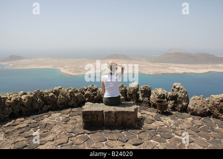 Un touriste jouit d'une vue spectaculaire de l'île de la Graciosa, du Mirador del Rio à Lanzarote. Banque D'Images