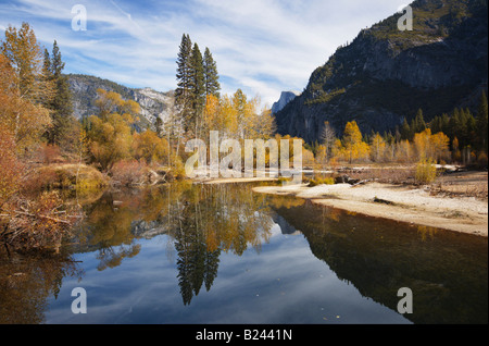 Demi Dôme se reflète dans les eaux calmes de Merced River au milieu des couleurs de l'automne dans la vallée de Yosemite Sierra Nevada en Californie Banque D'Images