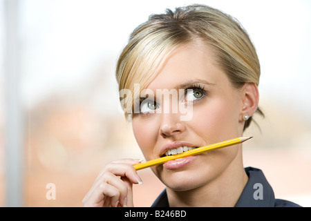 Un employé de bureau de mordre sur un crayon Banque D'Images