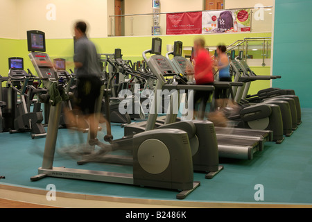 Les gens dans la salle de sport sur l'exécution de machines virtuelles, floue pour la vitesse et la puissance des effets dans une salle de sport Spa santé générique Banque D'Images