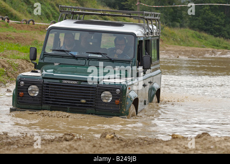 Land Rover en passant par une piste de terre inondée à Bining, France. Banque D'Images