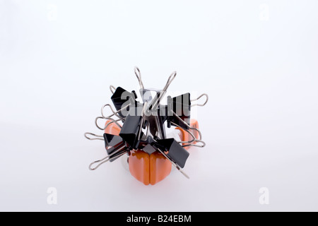Black binder clips réunis au sommet d'un métal orange clip studio Banque D'Images