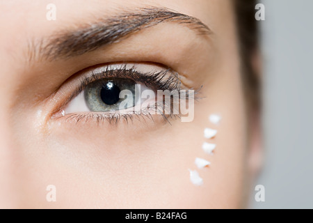 Femme avec une crème contour des yeux Banque D'Images