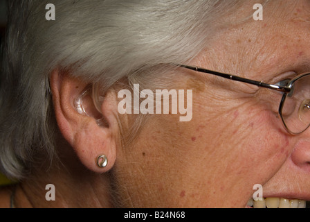 Stock photo d'une femme de soixante dix ans vêtue de son appareil auditif Banque D'Images