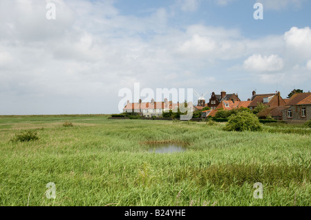 Le moulin sur la côte au petit village de Norfolk Claj suivant la mer, l'Angleterre vu à travers les maisons du village. Banque D'Images