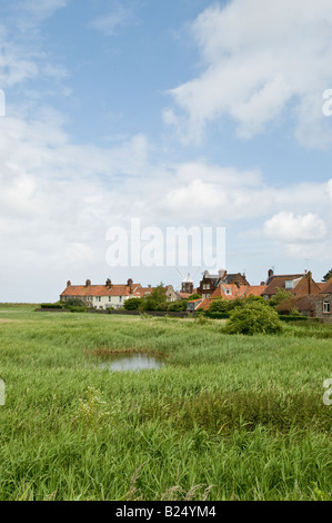 Le moulin sur la côte au petit village de Norfolk Claj suivant la mer, l'Angleterre vu à travers les maisons du village. Banque D'Images