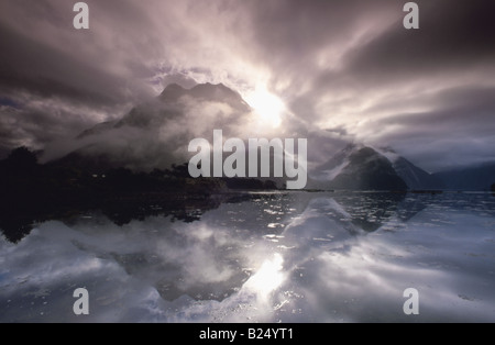 Milford Sound, Fiordland, Nouvelle-Zélande, vue du rivage, avec Mt Phillips (1445m), entourée de nuages et reflétée sur l'eau Banque D'Images