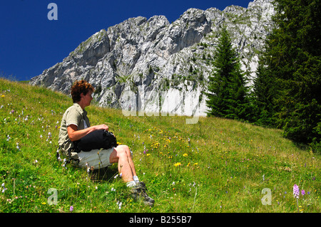 Femme prend une pause sur une randonnée sous la montagne, Préalpes fribourgeoises Gastlosen, Suisse Banque D'Images