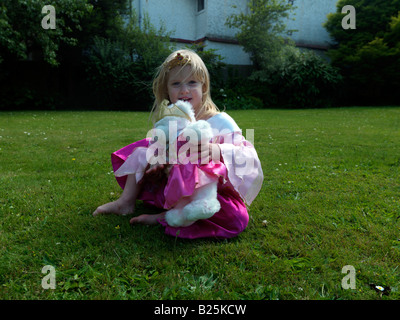 Fille habillée comme princesse avec un ours de princesse dedans A Garden Surrey Angleterre Banque D'Images