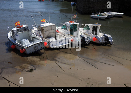 Petits bateaux de pêche s'échouer dans le port de Llanes, Asturias, à marée basse Banque D'Images