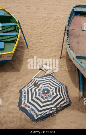 Sans-abri dormir sous un parasol sur la plage dans les îles Canaries Banque D'Images