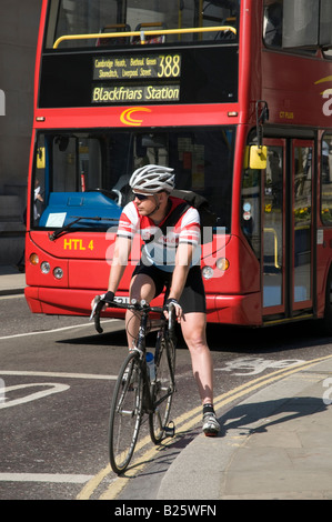 Casque cycliste portant la ligne d'arrêt à l'attente aux feux de circulation dans la ville de London, England, UK Banque D'Images