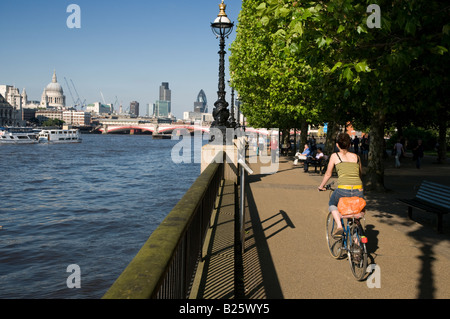 Vélo femme à côté de la rivière Thames London England UK Banque D'Images