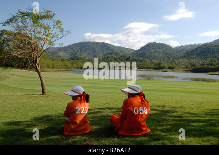 Deux femmes assises sur l'herbe, caddy, Kirimaya Golf Course, parc national Khao Yai, Thaïlande Banque D'Images